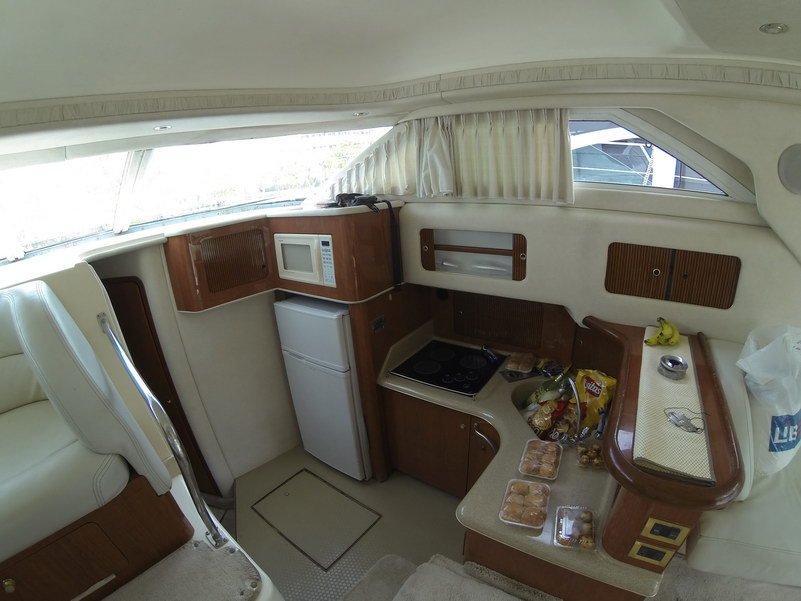 Cocineta del Sea Ray 44 con microondas, refrigerador, estufa y bocadillos servidos para un paseo de día