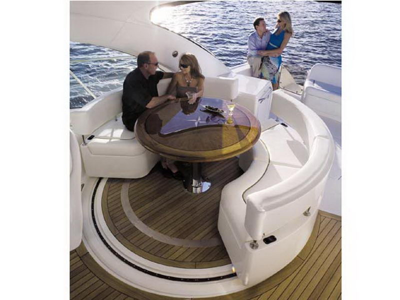 Couples relaxing around the circular teak cocktail table on the aft deck of the 55 ft Sea Ray luxury yacht charter