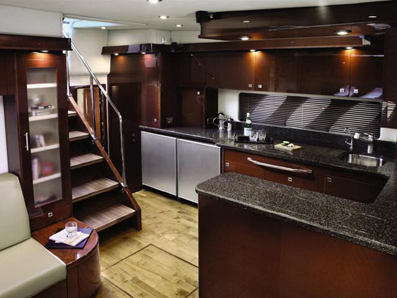 Gourmet galley of the 55 ft Sea Ray luxury yacht with granite counters, rich wood cabinetry and stairway to the salon
