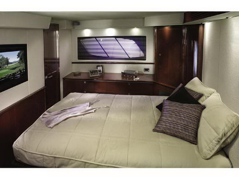 Spacious guest stateroom with queen bed and flat-screen TV aboard the 55 ft Sea Ray luxury yacht rental Cancun