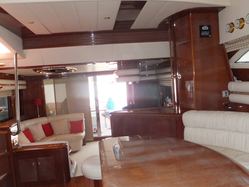 Open-plan salon of Nuvaris 63 ft charter yacht showing cream sofas, mahogany bar divider and aft deck sliding door