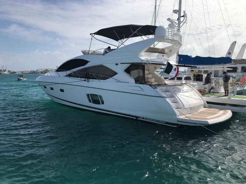 Isla Mujeres marina showing white hull, flybridge and Mexican flag flying