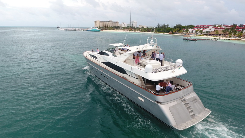 Megayate Azimut 100 pies navegando frente a la costa de Cancún con grupos celebrando en cubierta superior