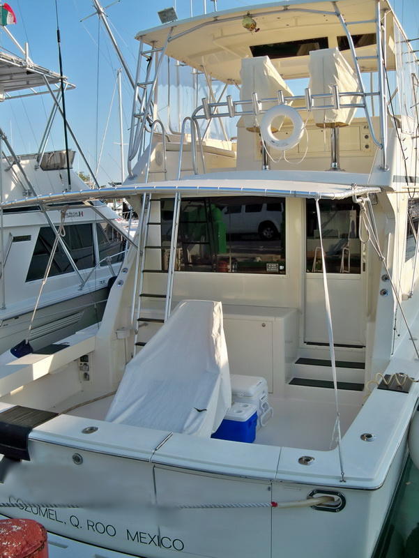 Pescadores a bordo del Bertram 38 navegando el azul profundo frente a la Isla de Cozumel en busca de picudos