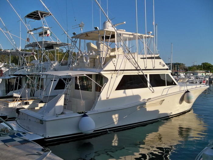 Barco de pesca Bertram 38 navegando el Caribe turquesa cerca de Cozumel para tours privados de pesca y esnórquel