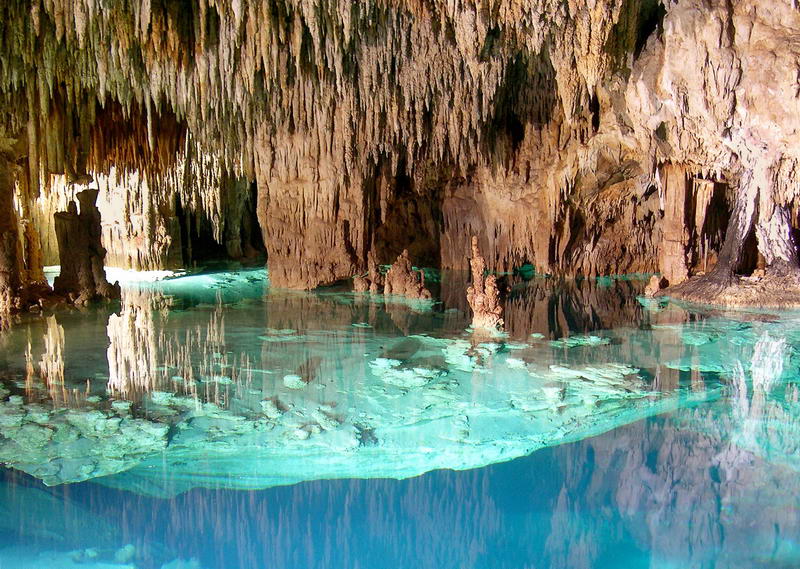 Cenote subterráneo y dramáticas formaciones rocosas vistas durante el tour por la cueva de Aktun Chen en la Riviera Maya