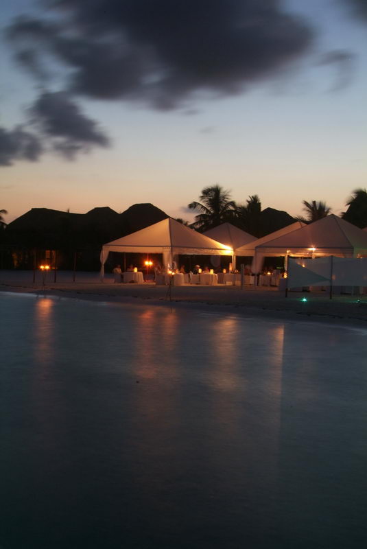 Cena de grupo en la playa al atardecer en Maroma, Riviera Maya, con el Caribe de fondo