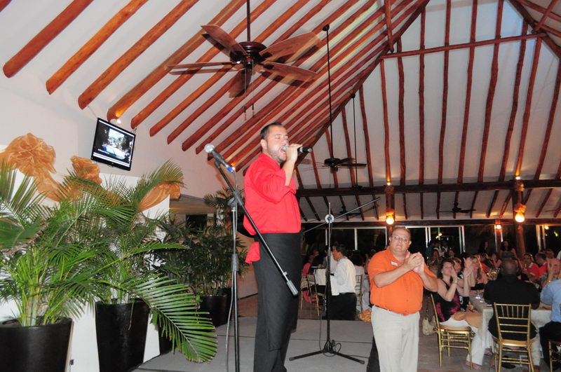 Cantante en vivo animando la cena de los invitados bajo la palapa del restaurante de Maroma durante un evento nocturno, Riviera Maya