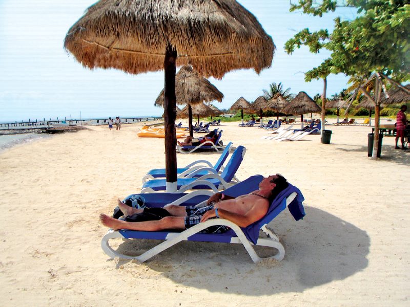 Playa de arena blanca en el beach club de Isla Mujeres, parada en los chárteres privados de catamarán desde Cancún