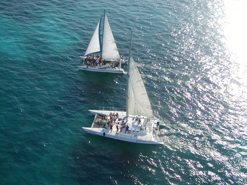 Catamarán Tiger fondeado en el mar Caribe turquesa cerca de Isla Mujeres en un chárter privado desde Cancún