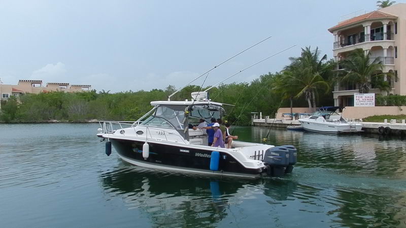 Grupo a bordo de la Wellcraft 30 pies con cañas preparadas navegando por el canal de marina Puerto Aventuras Riviera Maya
